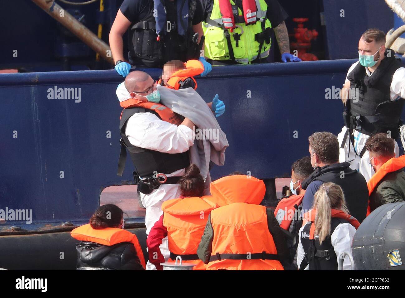 ANMERKUNG DER REDAKTION: BILD VERPIXELT VON PA-BILDTISCH Grenztruppen-Offiziere bringen ein kleines Kind an Land, das als Migrant gilt, nachdem eine Gruppe von Menschen nach einem kleinen Bootsunfall im Kanal von der RNLB Fraser Flyer nach Dover, Kent gebracht wurde. Stockfoto