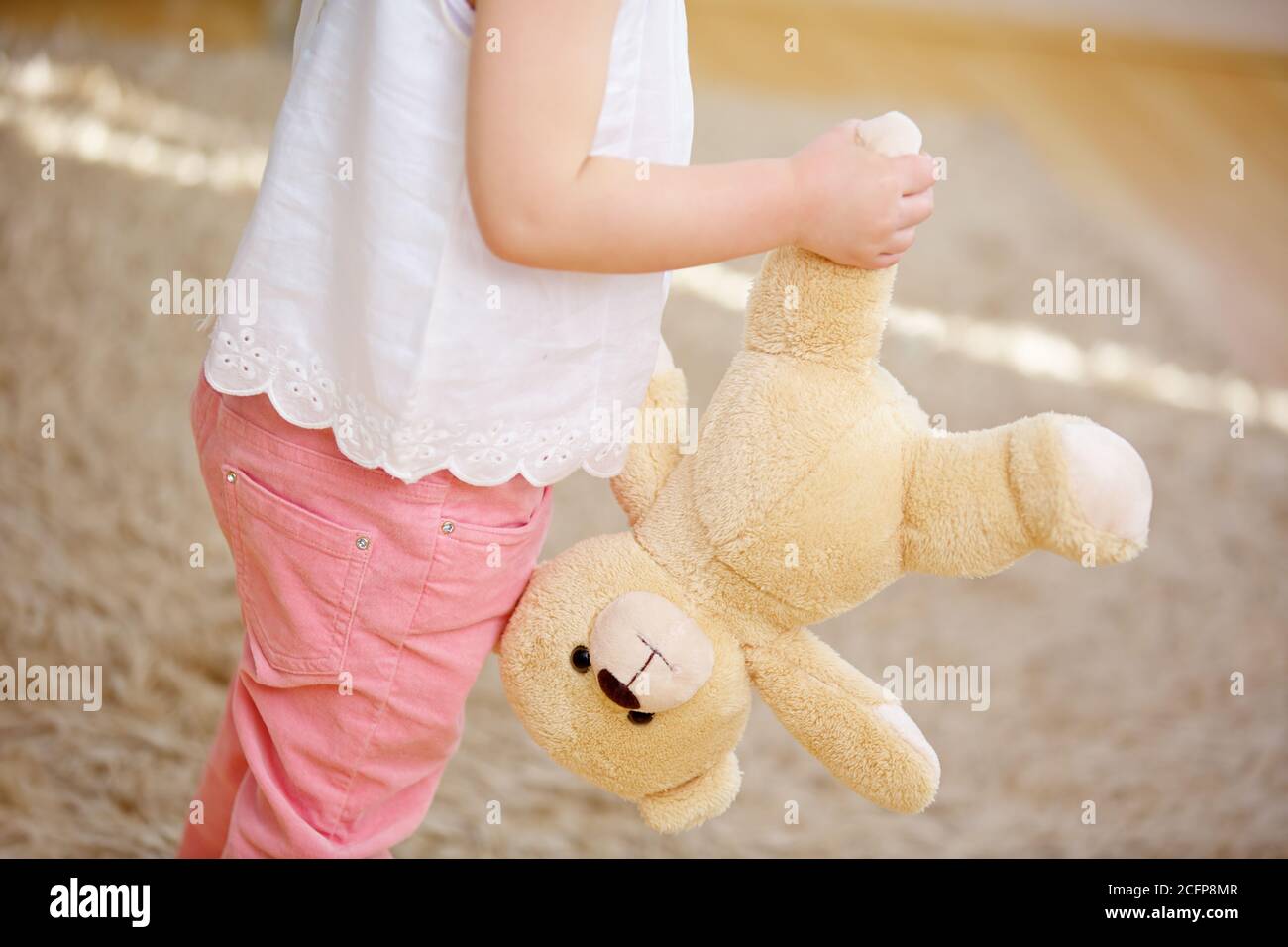 Kind trägt ein weiches Kuscheltier auf dem Kopf Bein Stockfoto