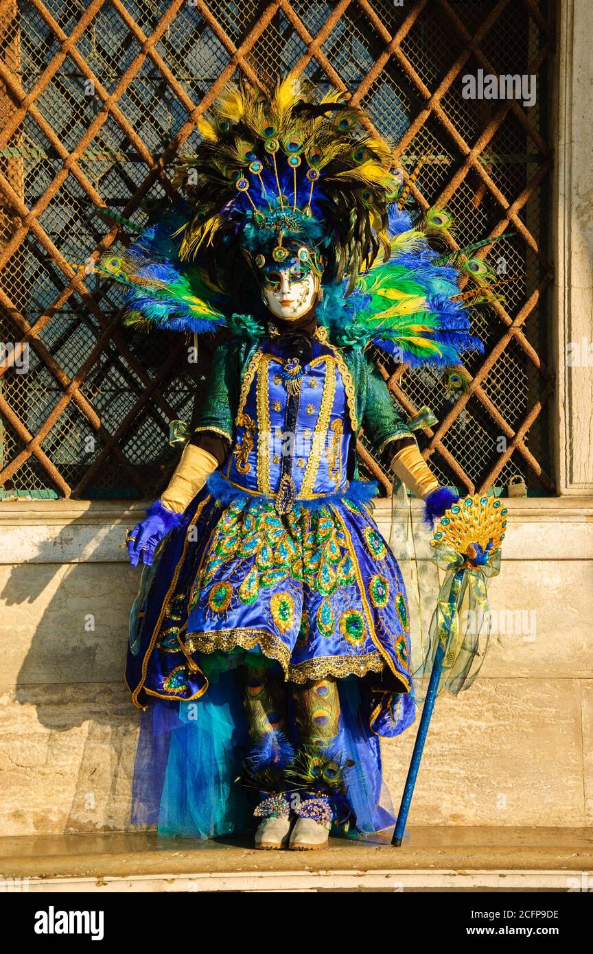 VENEDIG, ITALIEN - 16. FEBRUAR 2015: Pfauenmaske im Sonnenlicht in der Nähe des Dogenpalastes auf dem Markusplatz während des traditionellen Karnevals. Der Karneval in Venedig Stockfoto