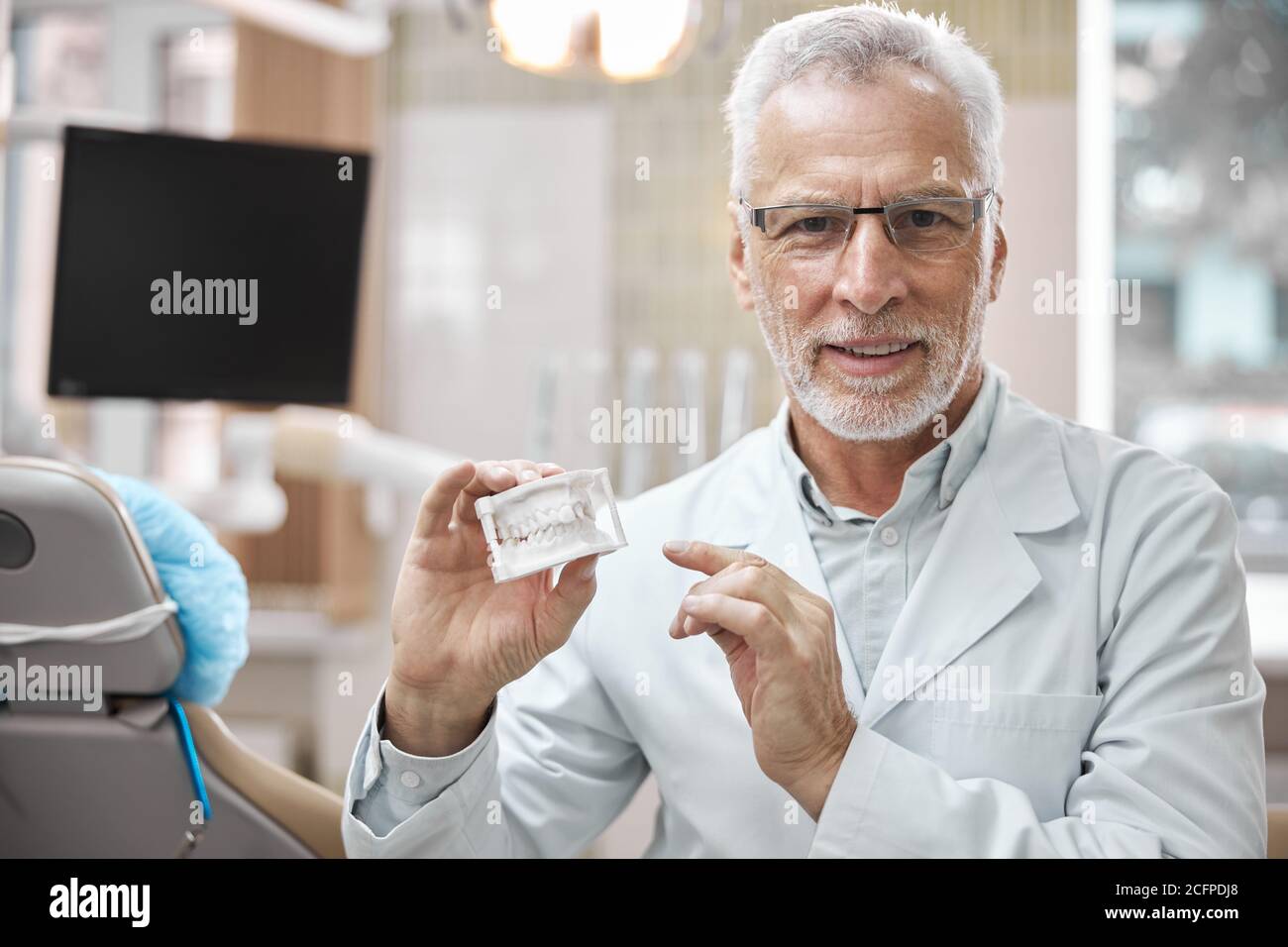 Professionelle zahnärztliche Experte hält ein Gipsmodell der Kiefer Stockfoto