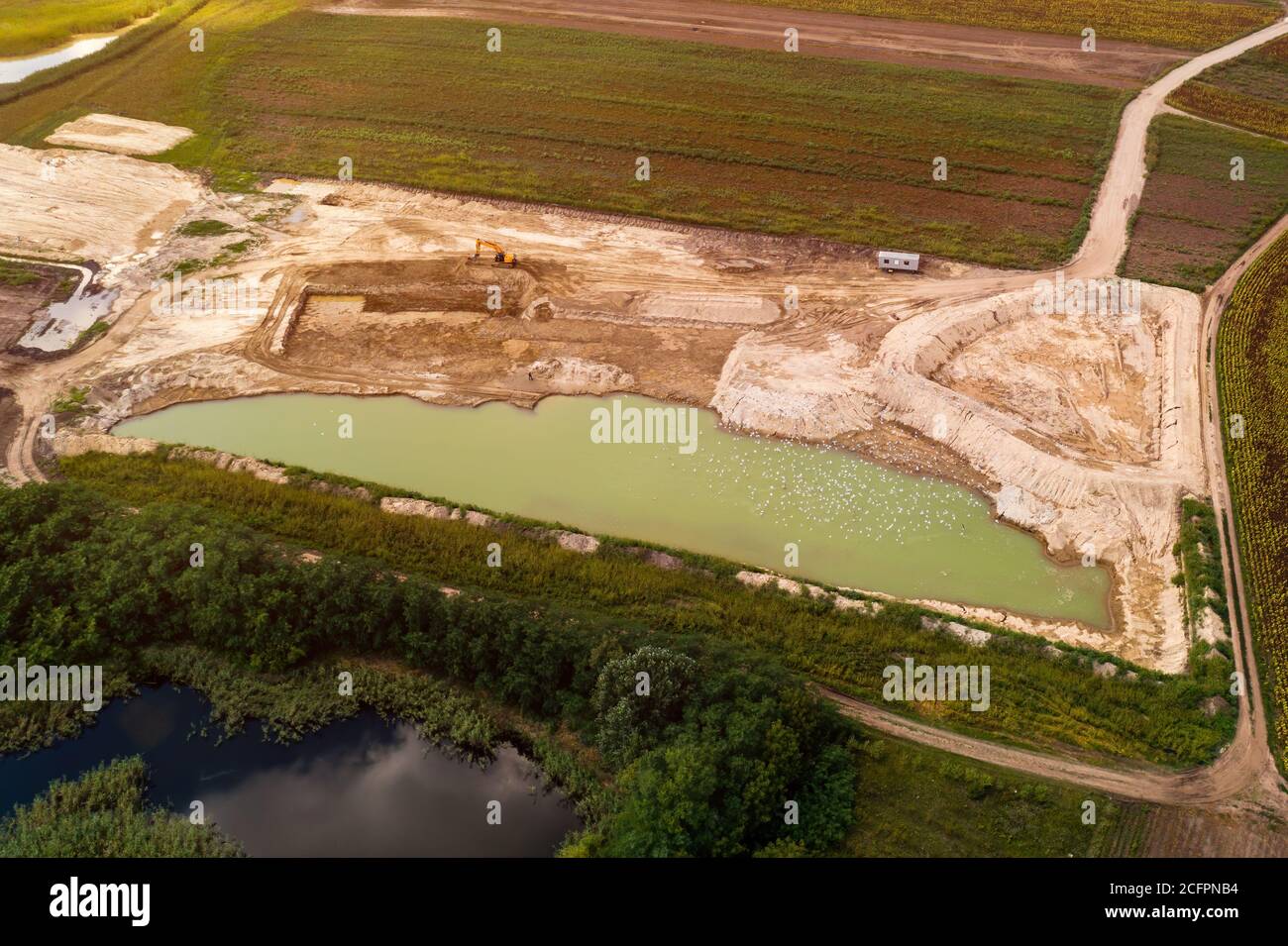 Luftaufnahme der Fischteich Baustelle von Drohne pov mit Baggermaschinen und große Pool von Wasser Stockfoto