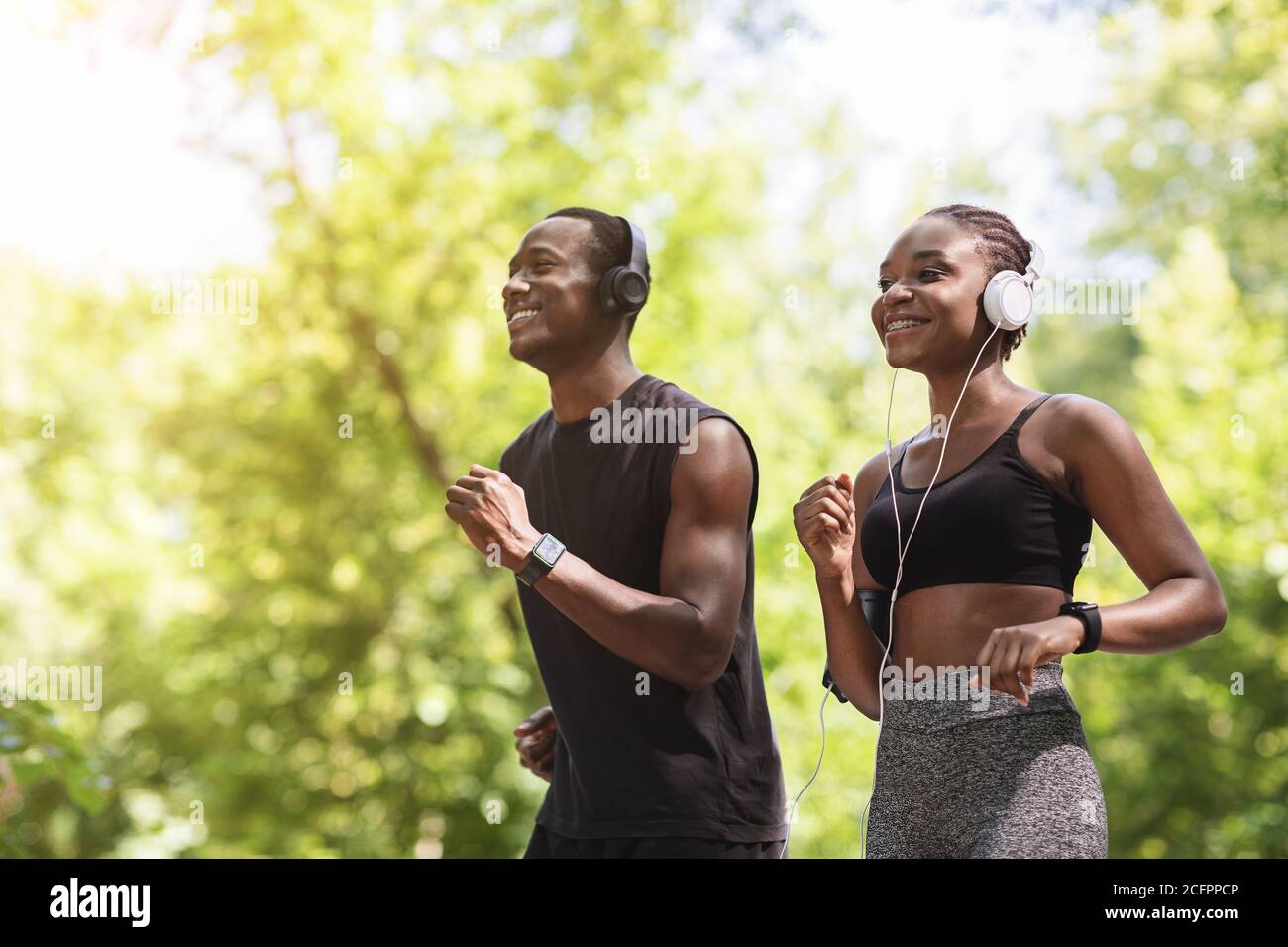 Genießen Sie Den Lauf. Fröhliches Afroamerikanisches Paar Beim Joggen Im Sommer Park Stockfoto