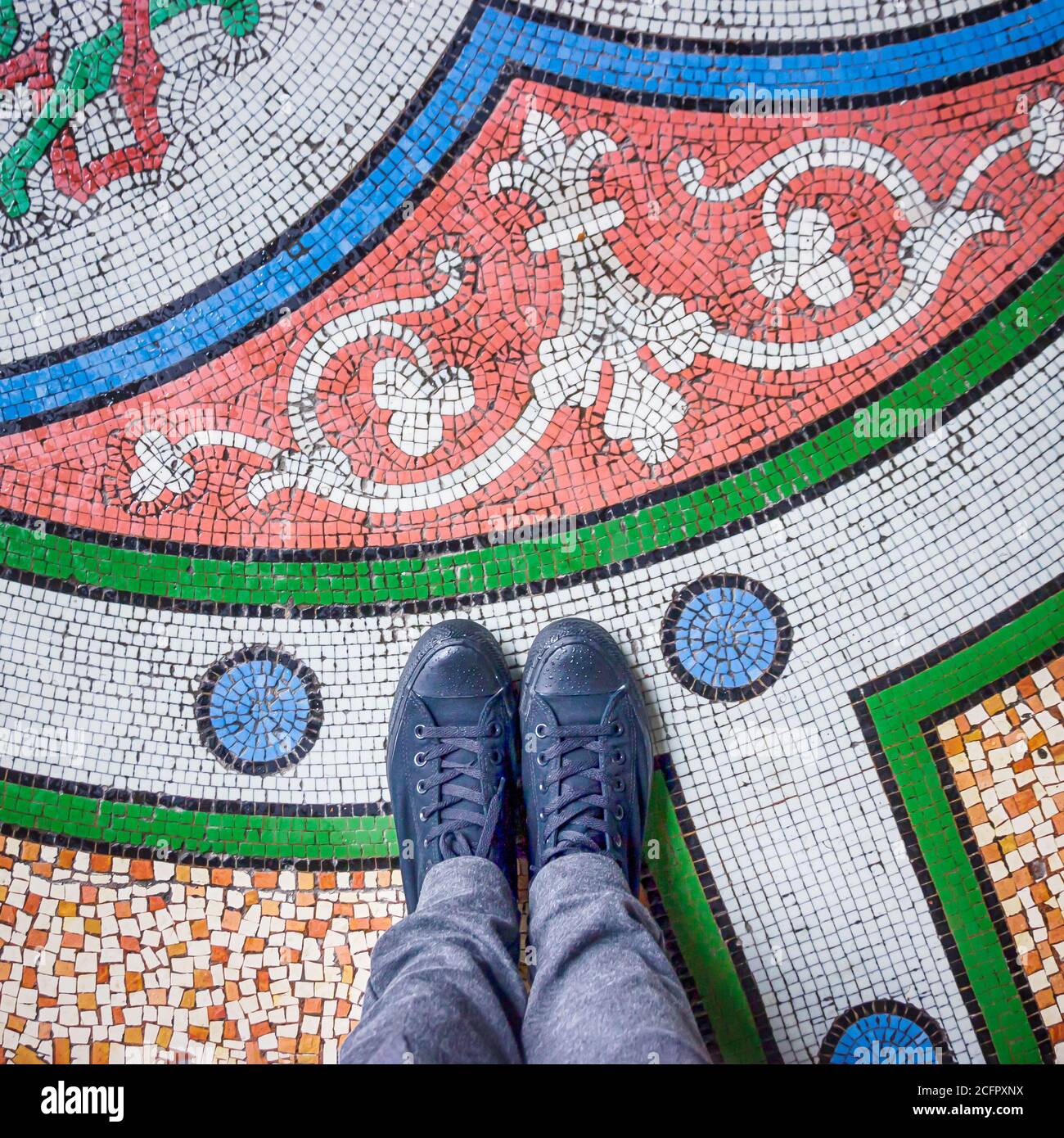 Füße Selfie mit schwarzen Schuhen auf bunt schönen Mosaikfliesen Boden, Draufsicht Stockfoto