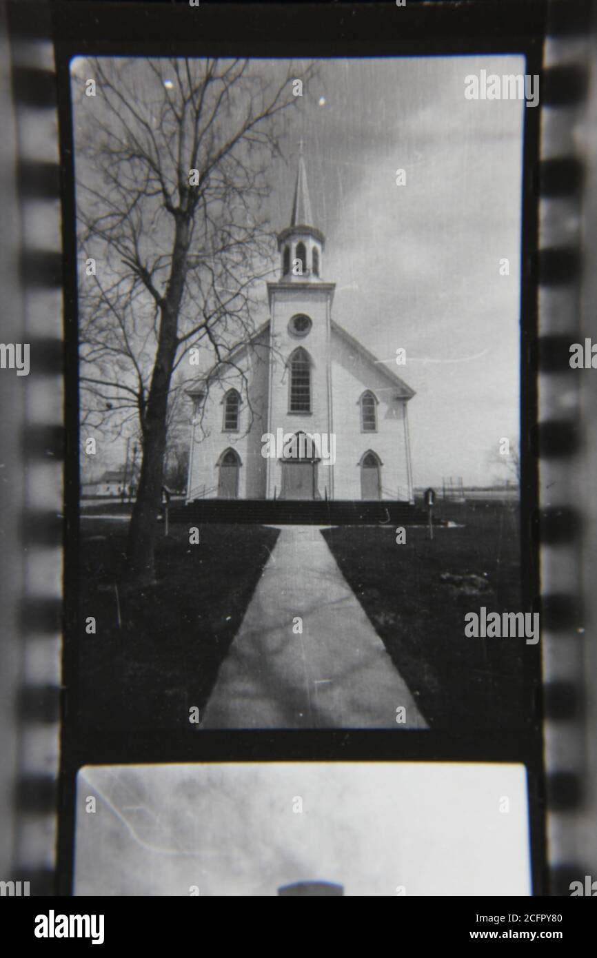 Schöne Schwarz-Weiß-Fotografie einer christlichen Kirche am Ende eines langen Weges aus den 1970er Jahren. Stockfoto