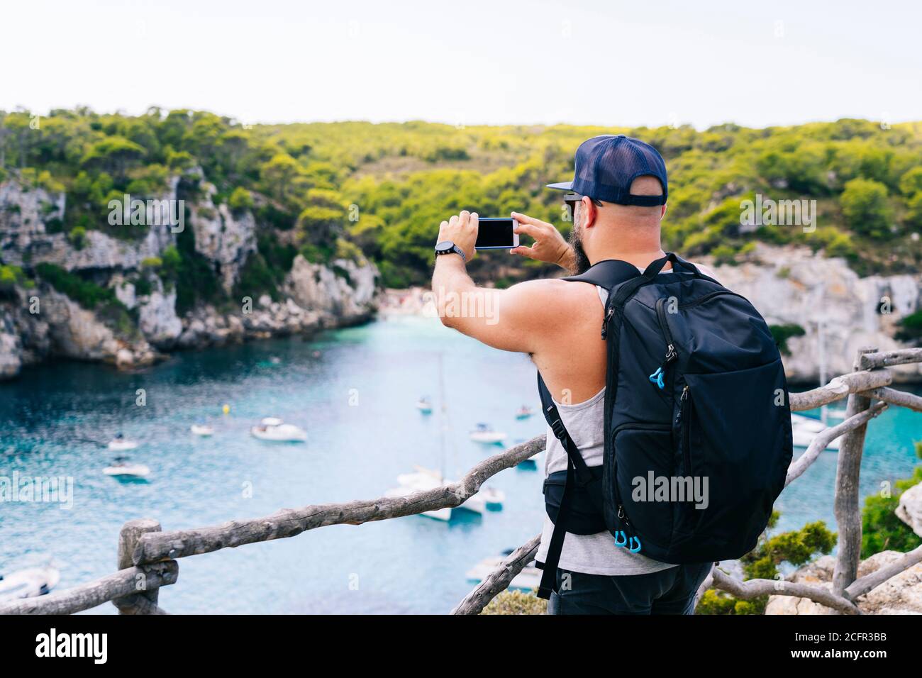 Tourist Mann mit Blick auf einen schönen Strand. Macarella Strand, Menorca Stockfoto