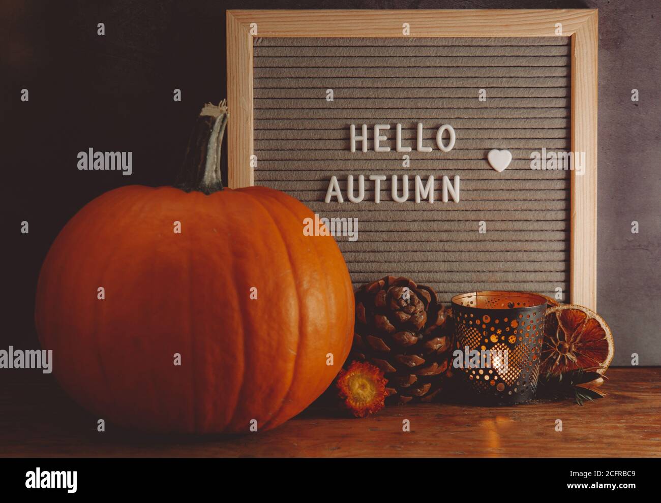 Hallo Herbstschild. Herbst-Mood-Board. Herbstkomposition mit Kürbis, Kiefer, Kerze und Message Board. Gemütliche Herbststimmung. Stockfoto