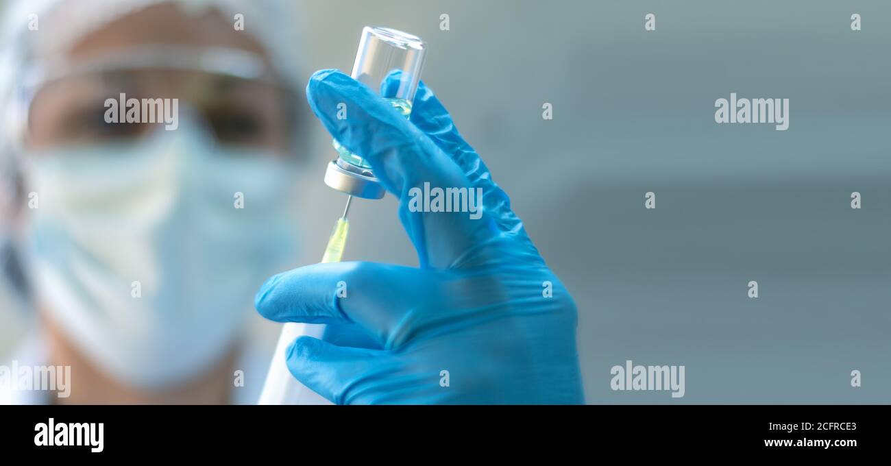 Biologie und Wissenschaft. Wissenschaftler mit einer Spritze und einer Impfstoffflasche. Globale Warnung. Impfung. Covid-19. Coronavirus. Forschung. Stockfoto