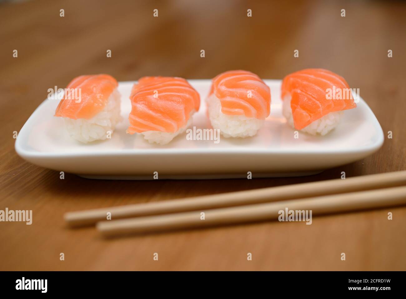 Essstäbchen und Sushi mit Lachs auf der Bambusmatte Stockfoto