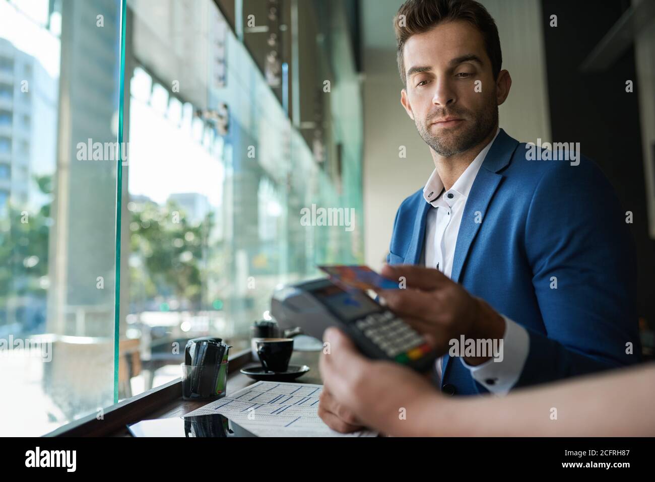 Mann, der seinen Kellner mit einer Karte und nfc-Technologie bezahlt Stockfoto
