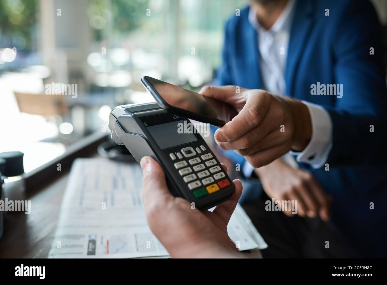 Mann bezahlt seinen Kellner mit einem Smartphone und nfc Technologie Stockfoto