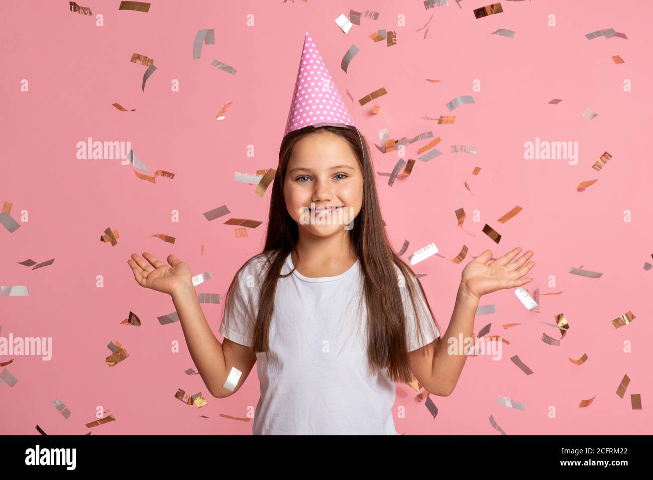 Kindheit, Stimmung und Emotionen. Lächelndes kleines Mädchen genießen Konfetti zum Geburtstag Stockfoto