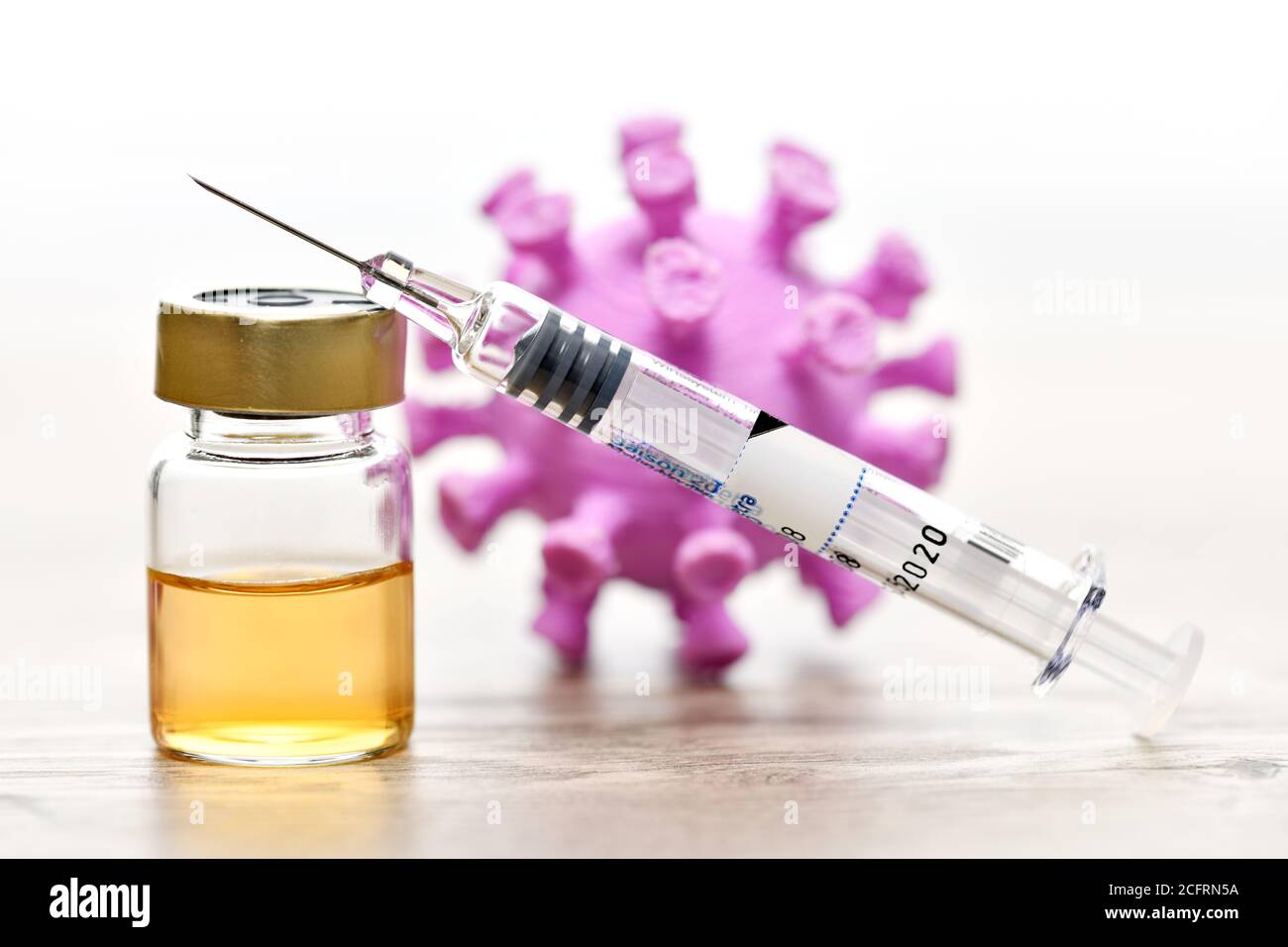 Spritze und Corona-Impfstoff vor dem Coronavirus-Modell, COVID-19-Impfung Stockfoto