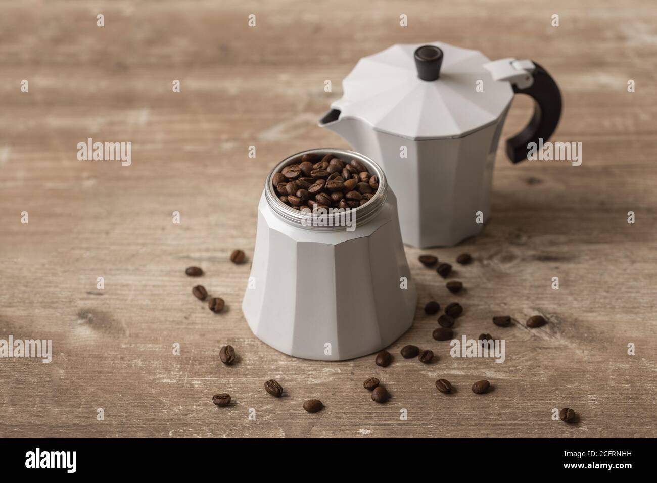 tasse Kaffee mit Bohnen im Inneren, auf einem Holztisch Stockfoto