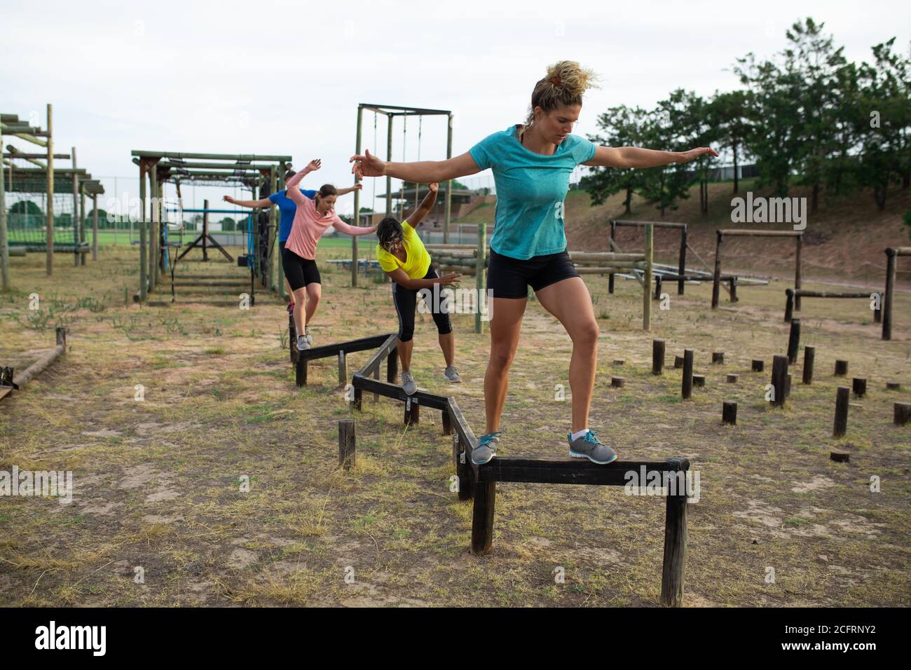 Eine Gruppe von Frauen, die im Boot Camp durch einen Hindernisparcours laufen Stockfoto