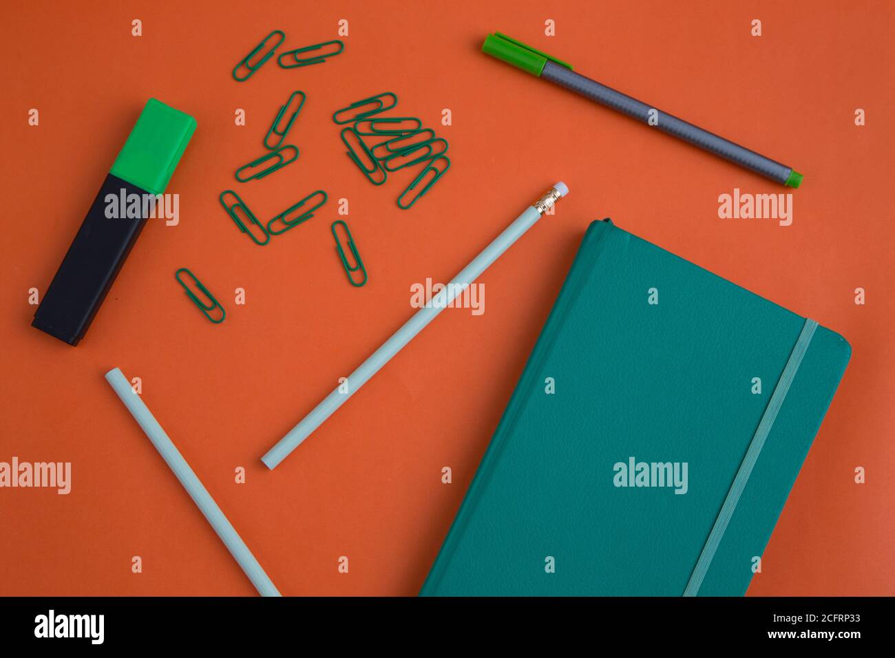 Bleistifte, Stift, Clips und ein Notizbuch und Textmarker Stift, Büroobjekte auf einem lustigen farbigen Hintergrund Stockfoto