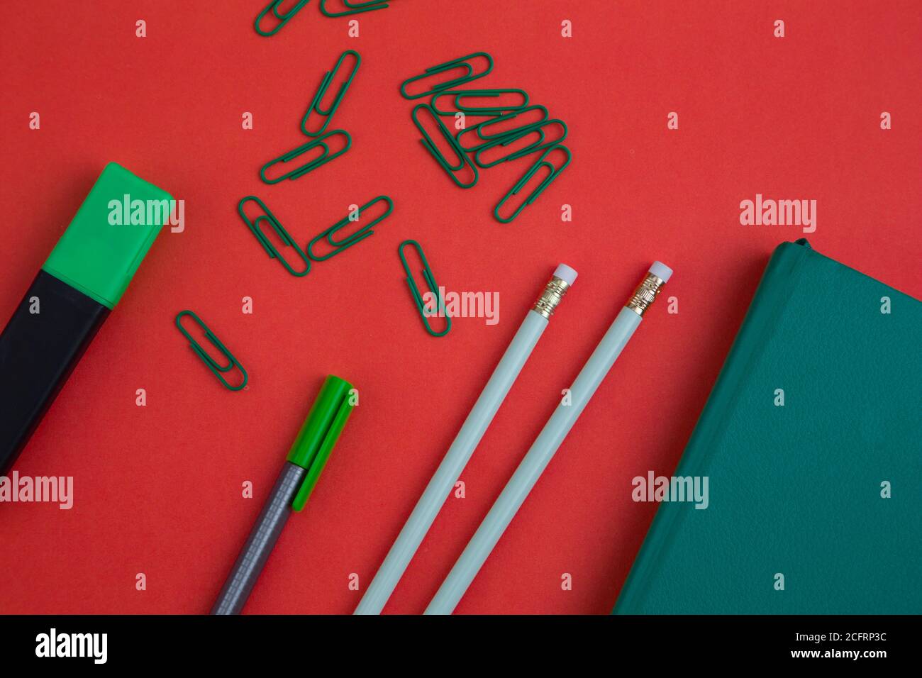 Bleistifte, Clips, ein Buch, Marker und Büroobjekte auf farbigem Hintergrund, Spaß, Nahaufnahme von Details Stockfoto