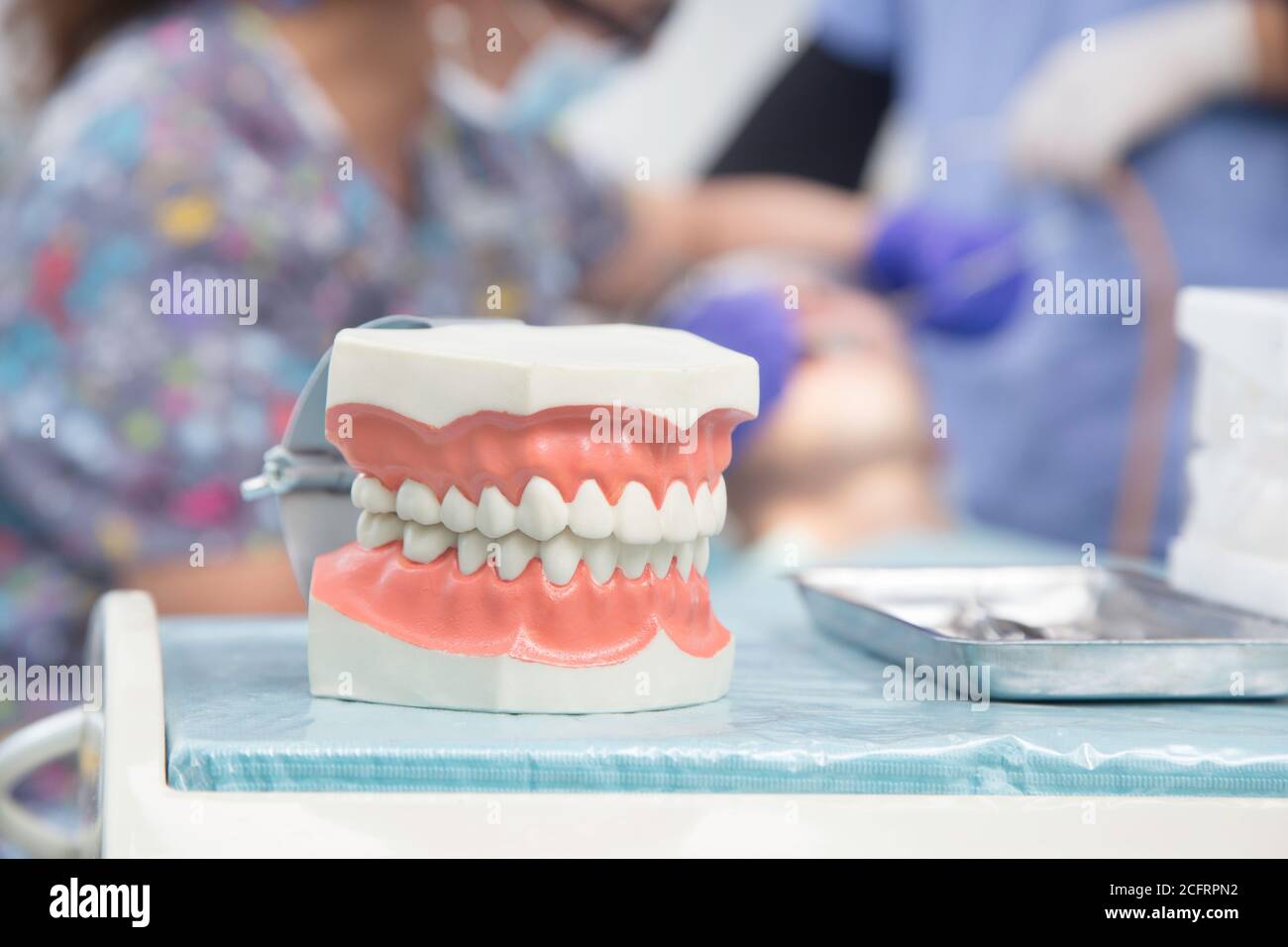 Zahnärztliche Werkzeuge und Zähne im Hintergrund ein Zahnarzt mit Ein Patient Stockfoto