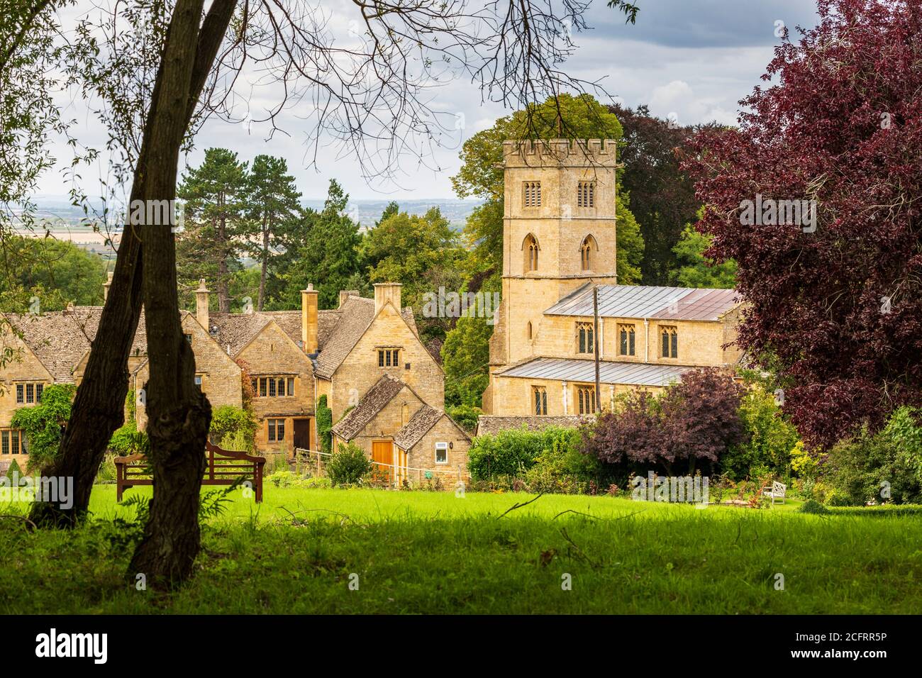 Die Kirche St. Michael im Cotswold-Dorf Buckland vom Gelände des Buckland Hotels, Gloucestershire, England Stockfoto