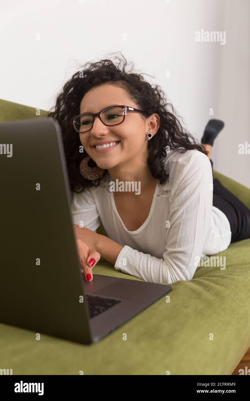 Schöne Frau, die zu Hause mit einem Computer arbeitet und mit sozialer Distanzierung arbeitet Stockfoto