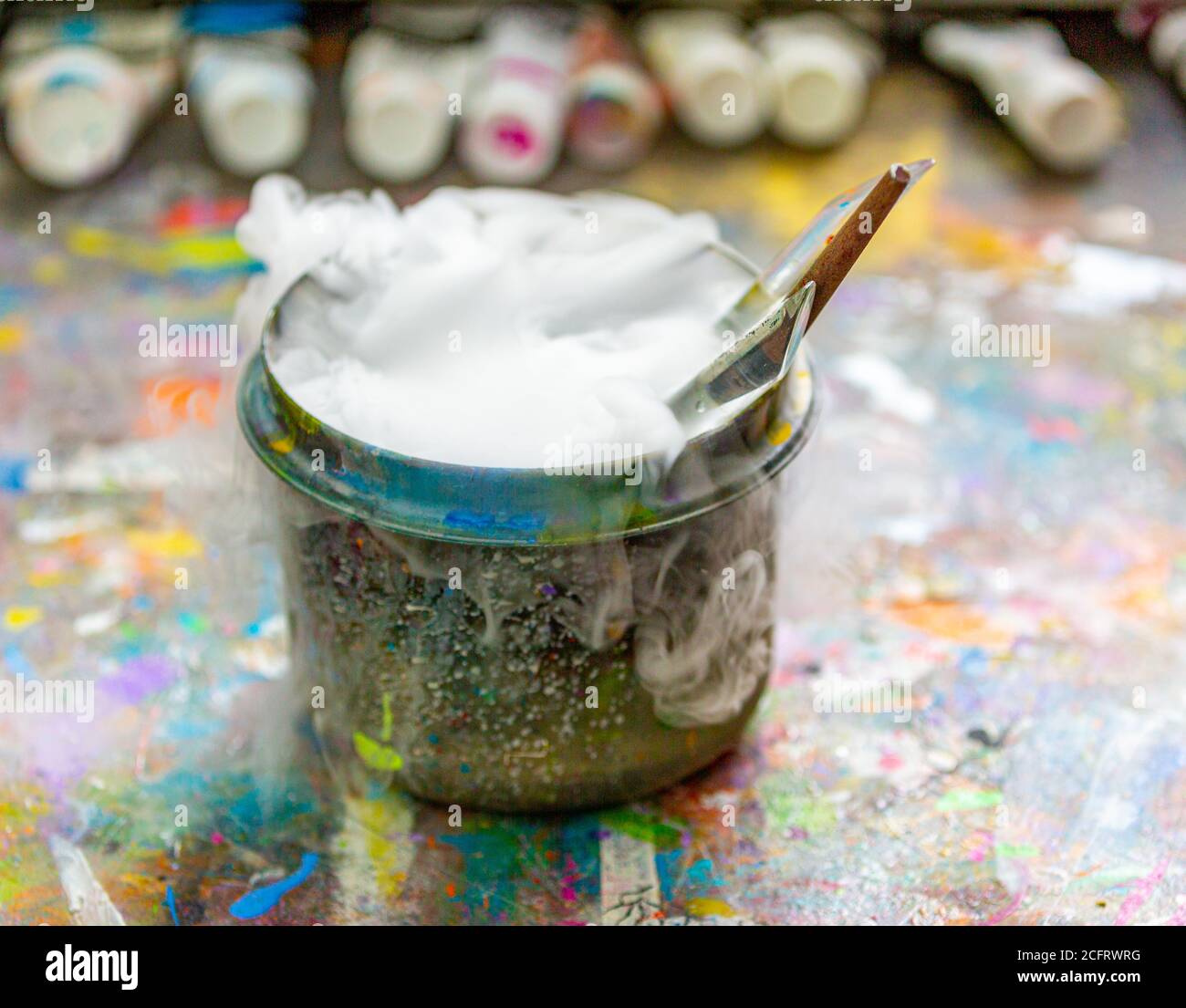 Künstlerpinsel in einem sprudelnden Behälter mit Wasser Stockfoto