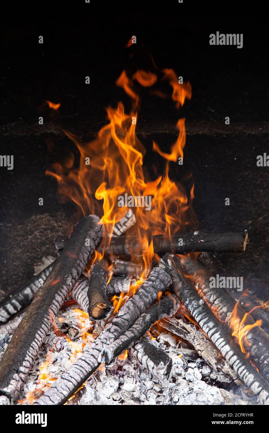 Brennende Holzstämme auf Steinofen. Speicherplatz kopieren Stockfoto