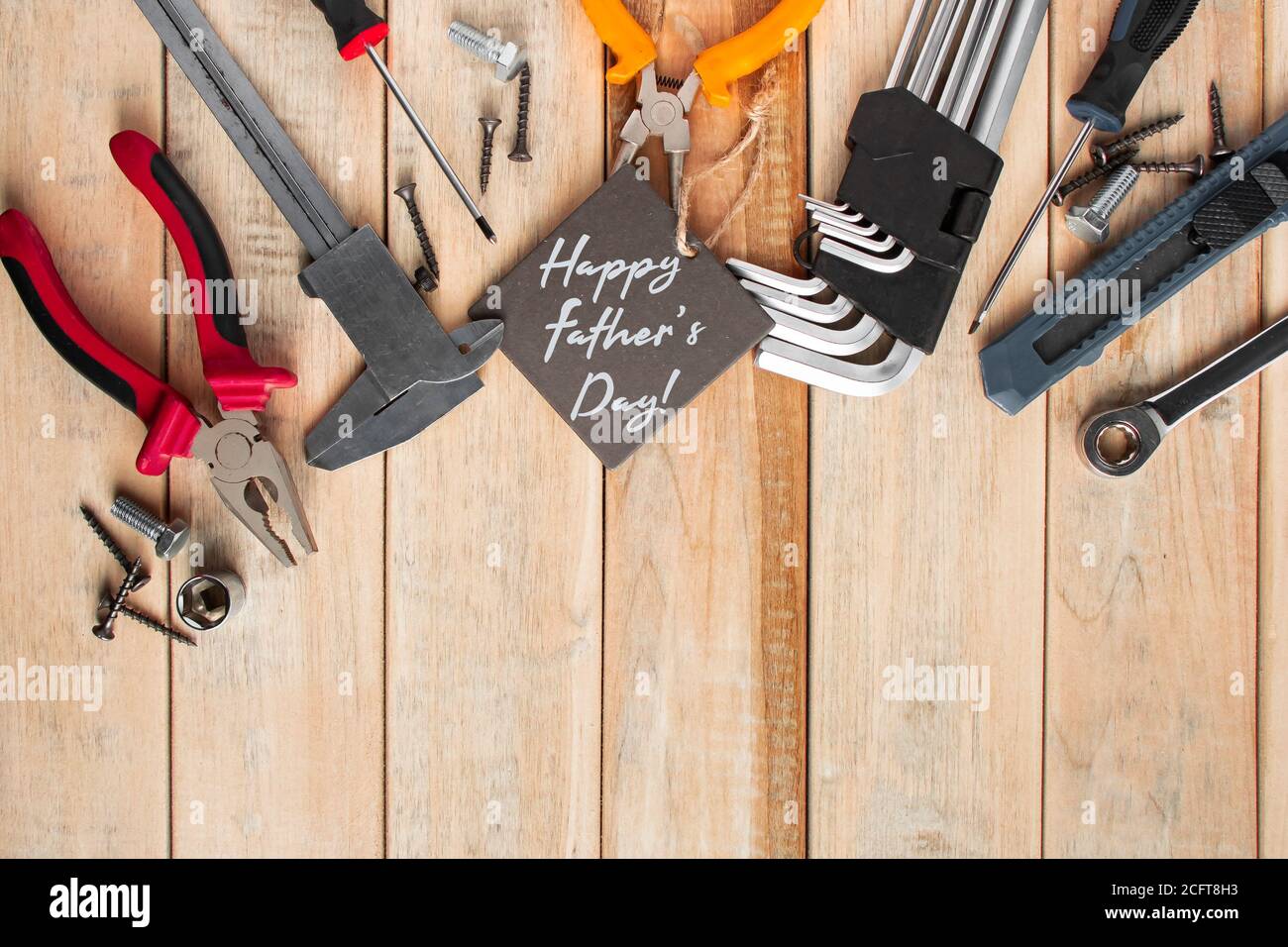 Set von Arbeitswerkzeugen auf einem hölzernen Hintergrund. Festliche Grußkarte Konzept für Vatertag Stockfoto