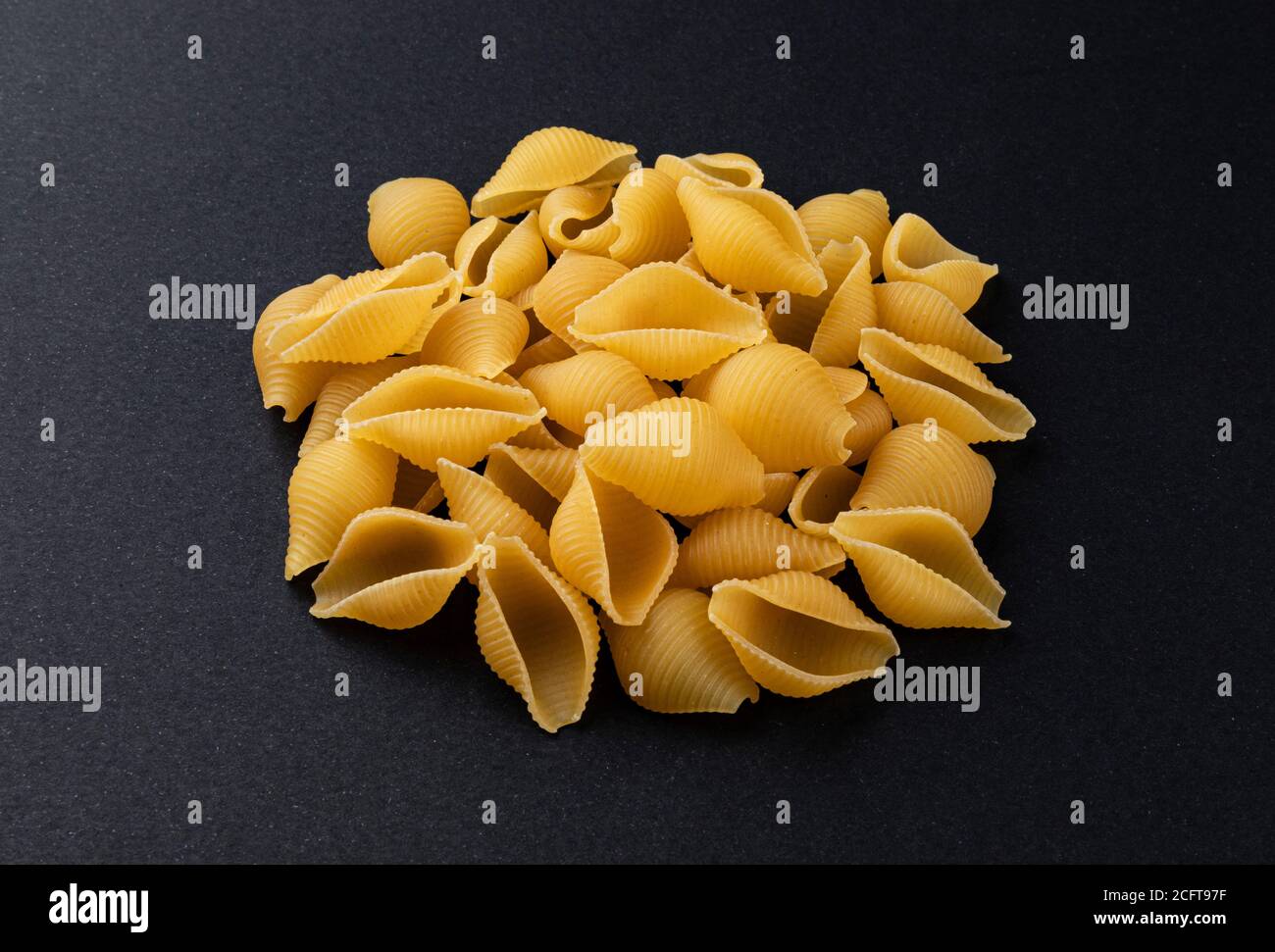 Conchiglie rigate. Roh gestreifte Muschel Pasta auf schwarzem Hintergrund Stockfoto