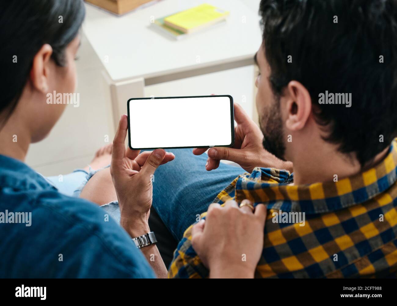Junges Paar Holding Telefon Mit Leerem Bildschirm Für Copy Space Stockfoto