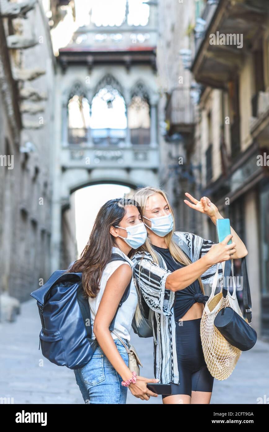 Zwei schöne weibliche Touristen, die ein Selbstportrait mit einem Smartphone in den Straßen der gotischen Gegend von Barcelona Stadt Stockfoto