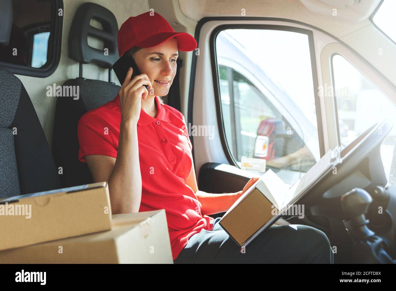 Delivery Frau im Van, die auf dem Handy spricht Stockfoto