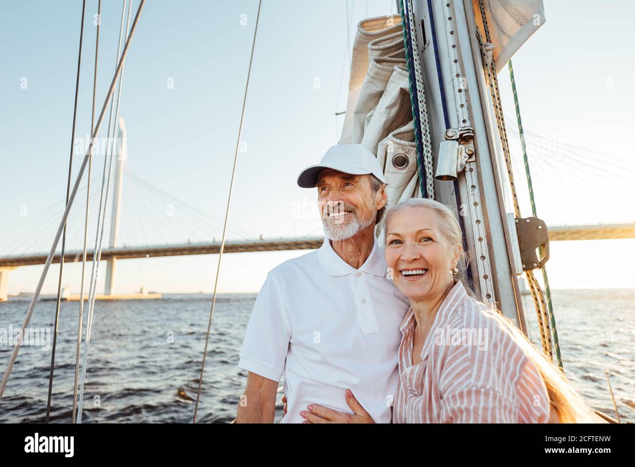 Glückliches Seniorenpaar, das am Mast steht. Zwei lächelnde Menschen genießen Bootsfahrt Stockfoto