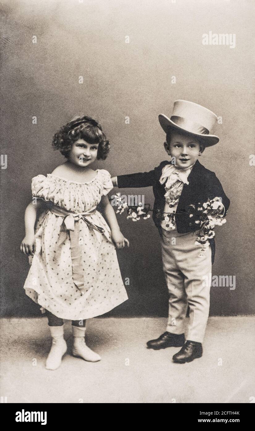 Foto von lustigen kleinen Mädchen und Jungen im Vintage-Dressing. Retro-Bild mit Original-Film Maserung und Kratzer Stockfoto