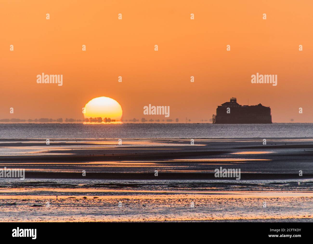 Solent Sunrise. Die Sonne geht neben dem No man's Land Fort im Solent auf, fotografiert vom Ryde Pier, Isle of Wight Stockfoto