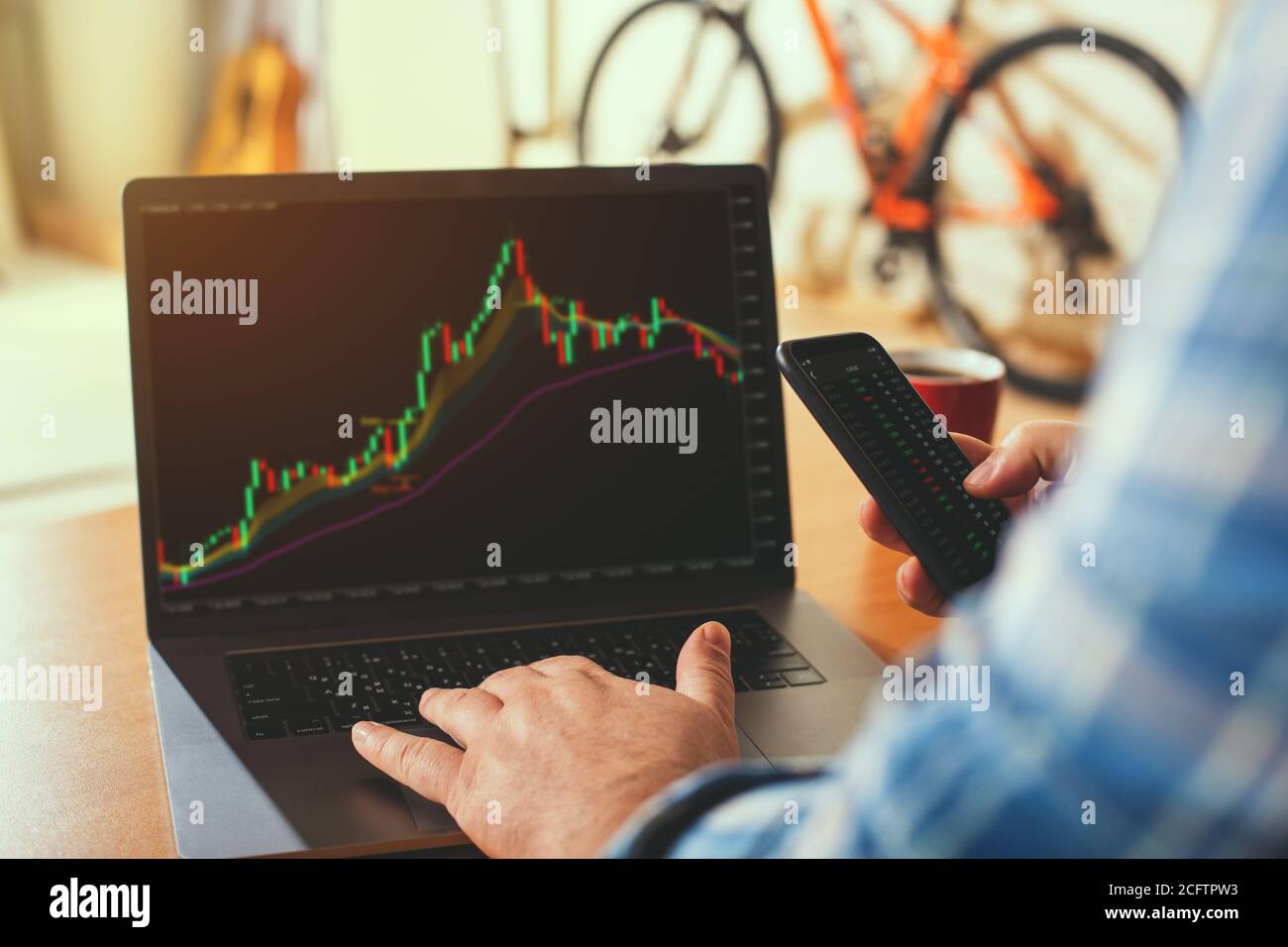 Ein Geschäftsmann oder Makler arbeitet von zu Hause aus Analyse der Börse für neue Investitionen. Konzept: Telearbeit zu Hause. Stockfoto