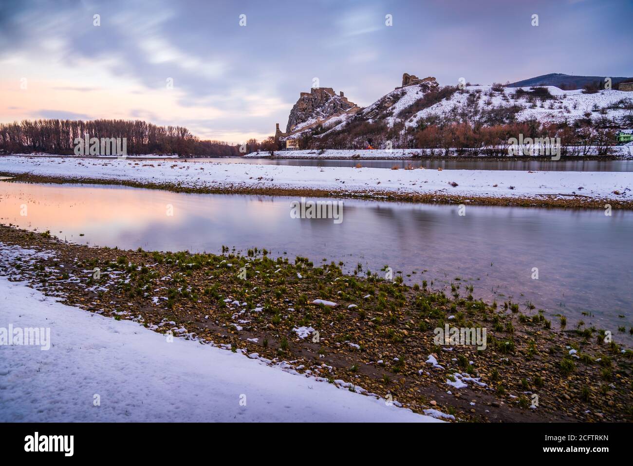 Schneebedeckte Ruinen der Burg Devin über der Donau in Bratislava, Slowakei bei Sonnenaufgang Stockfoto