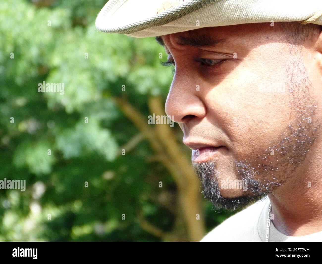 Porträt von Mauritian charismatisch schöner Mann in einem Hut arbeiten in einem Nationalpark Casela World of Adventures. Profil eines traurigen reflektierenden Mannes. Stockfoto Porträt von Mauritian charismatisch schöner Mann in einem Hut arbeiten in einem Nationalpark Casela World of Adventures. Profil eines traurigen reflektierenden Mannes. Stockfoto
