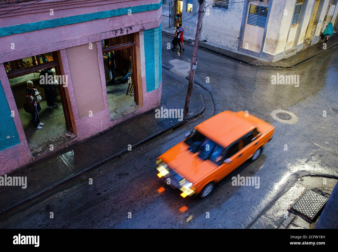 SANTIAGO DE CUBA, KUBA - CA. JANUAR 2020: Typische Straßenszene in Santiago de Cuba an einem regnerischen Tag. Stockfoto