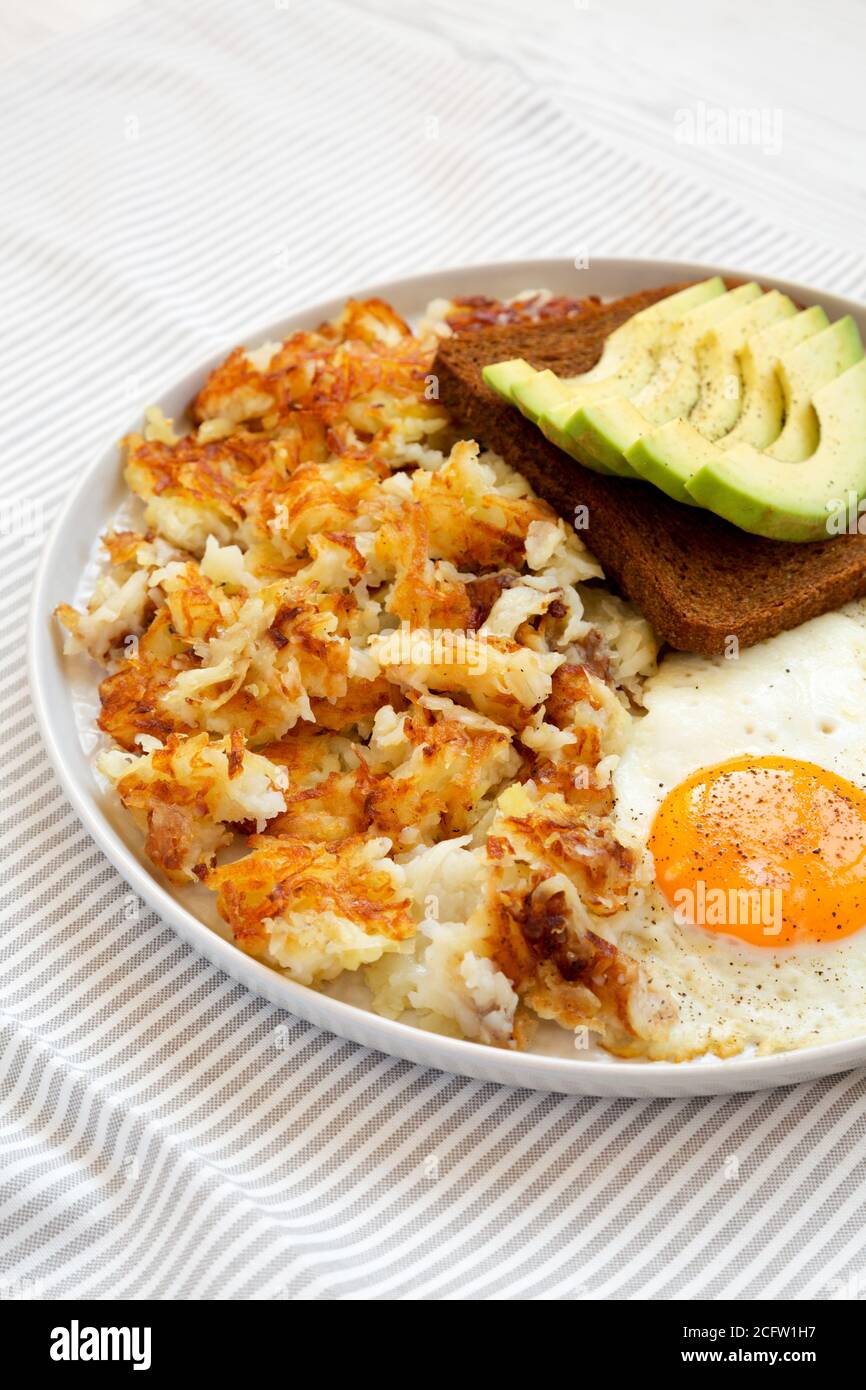 Leckere hausgemachte gebratene Hashbrowns und Eier auf einem Teller, Seitenansicht. Stockfoto