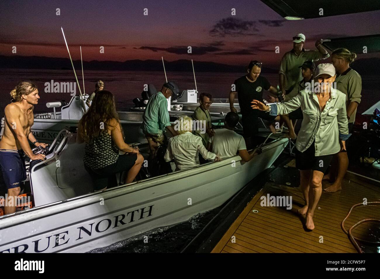 Die Schlauchboote kehren zurück und die Gäste können an den Tisch zum Abendessen bei der Fire and Dragons Cruise of the True North, Sunda Islands, Indonesia gehen Stockfoto