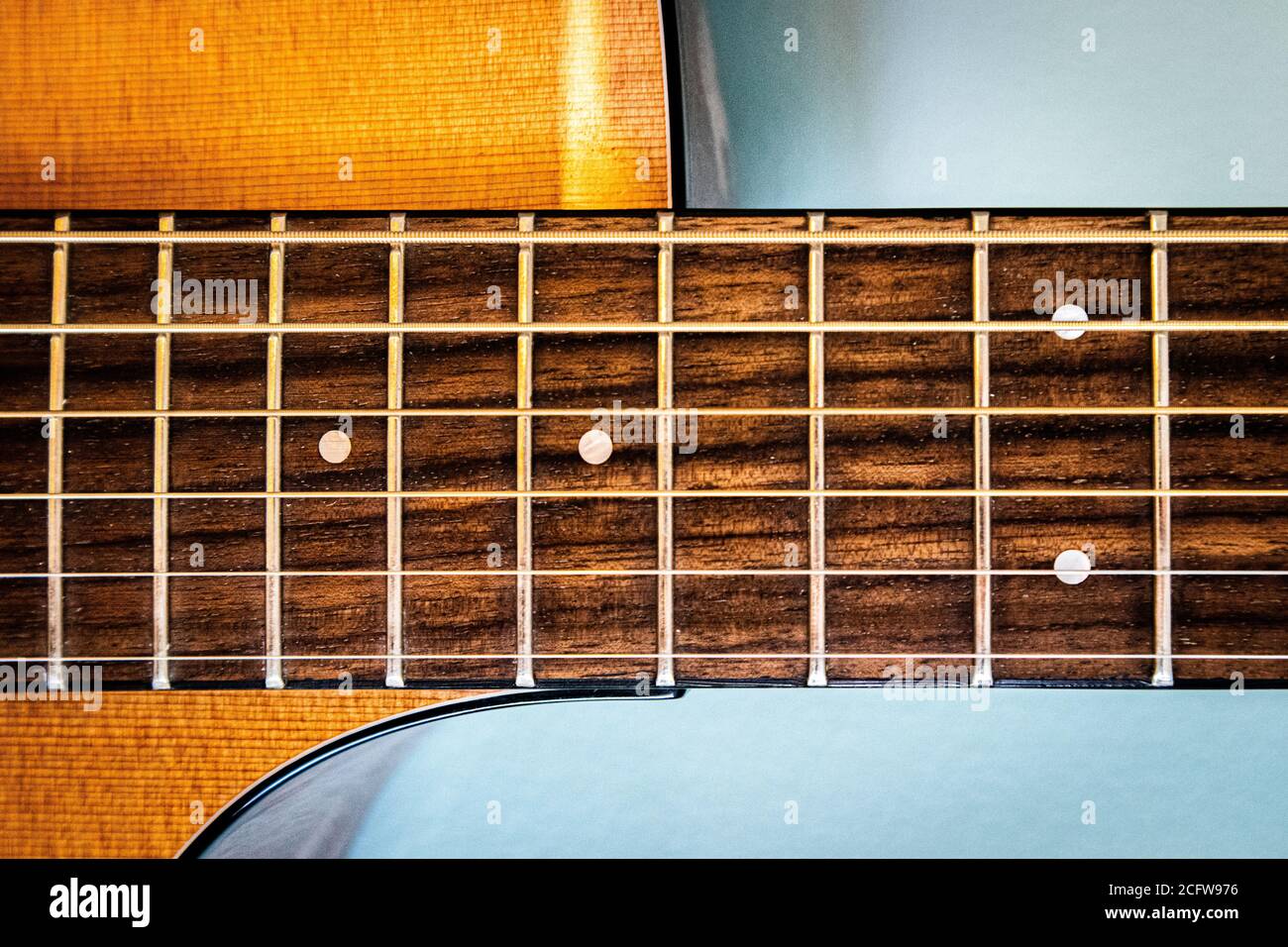 Nahaufnahme von 6 Saiter Gitarre Griffbrett und Zederndecke Auf blauem Hintergrund Stockfoto