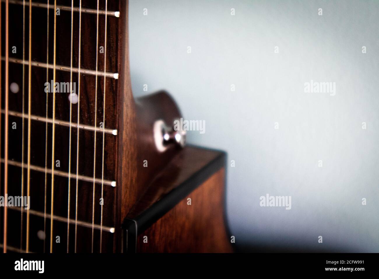 Nahaufnahme von 12 Saiter Gitarre Griffbrett vor solidem Hintergrund Stockfoto