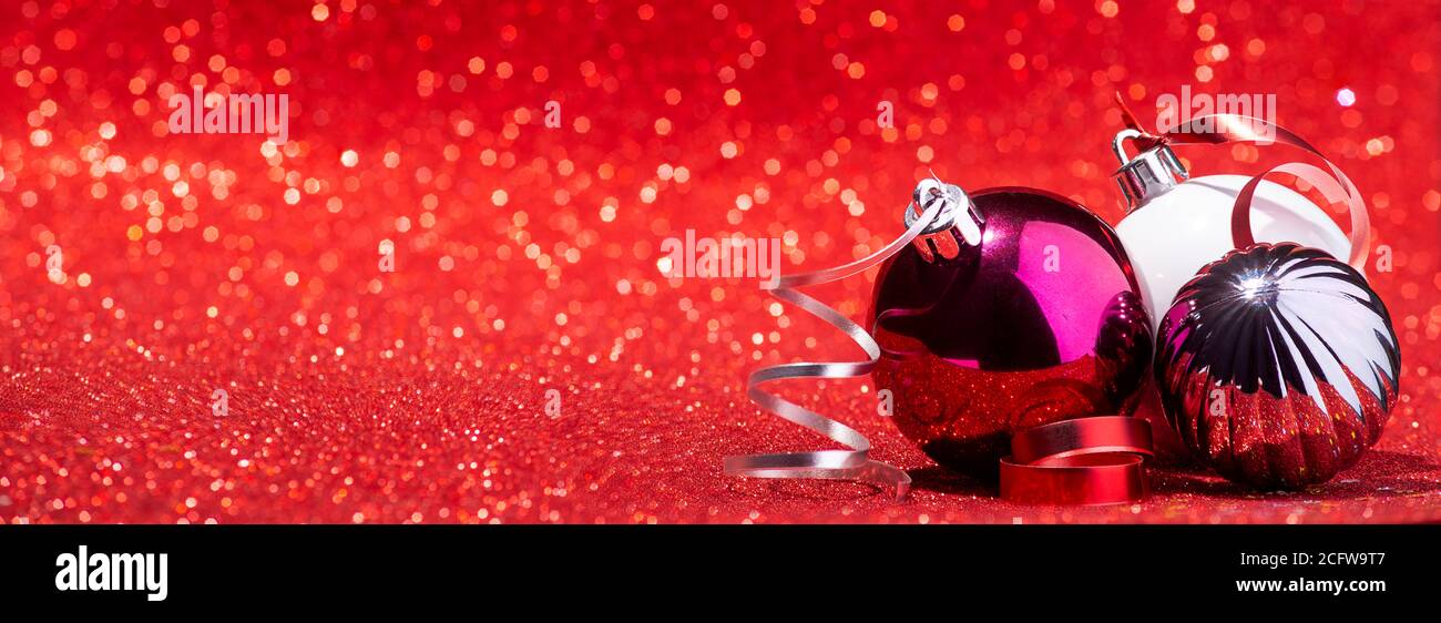 Weihnachtskugeln auf rotem Glitzer Hintergrund Banner Stockfoto