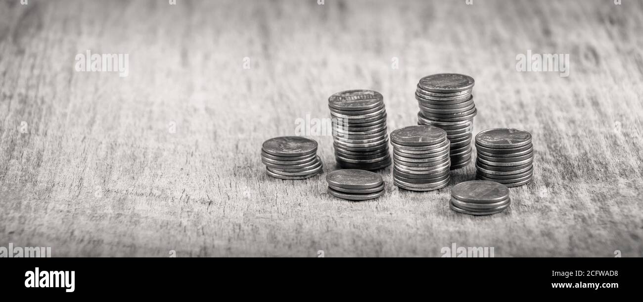 Stapel alter Groschen auf einem Holztisch in Schwarz Und weiß Stockfoto
