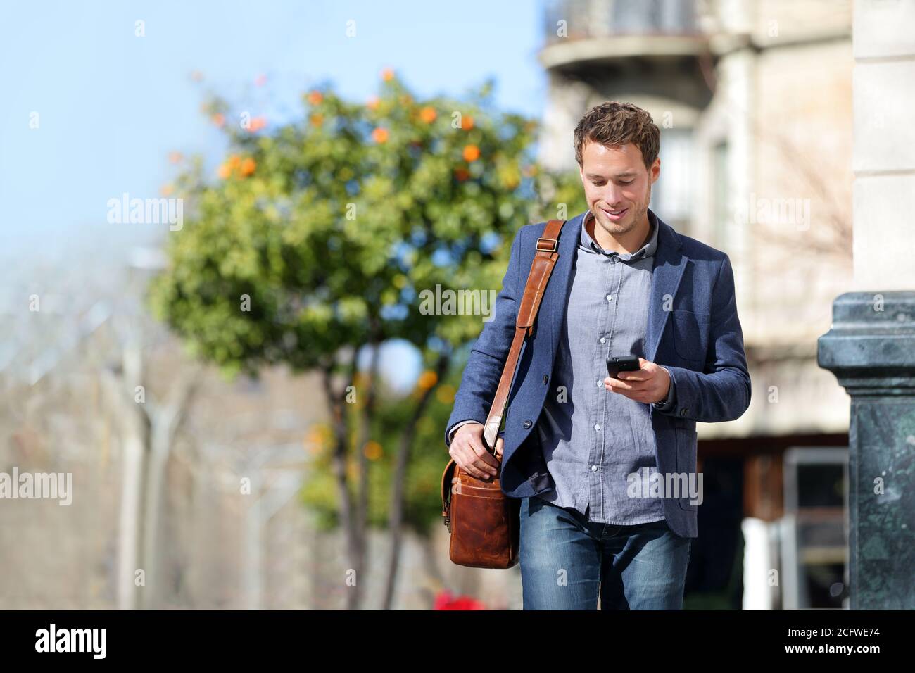Junge städtische Geschäftsmann Profi auf Smartphone zu Fuß in der Straße mit Handy-App SMS-SMS-Nachricht auf Smartphone tragen smart Lässig Stockfoto