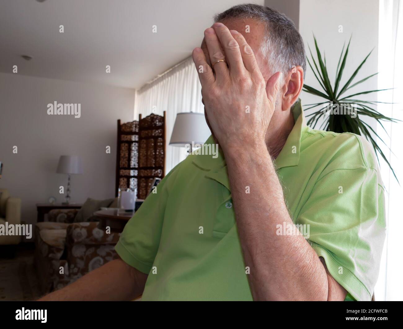 Mann versteckt Gesicht mit der Hand Stockfoto