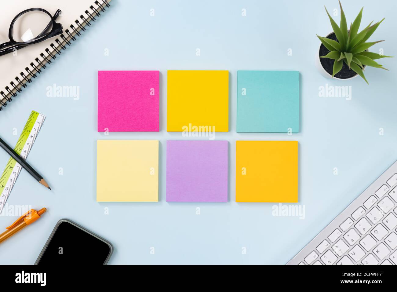 6 Haftnotiz oder Notizblock und Bürobedarf als Tastatur, Stift, Bleistift, Büropflanzen, Spiral-Notebook, Brille, Lineal, Handy auf Modern Clean Creative Stockfoto