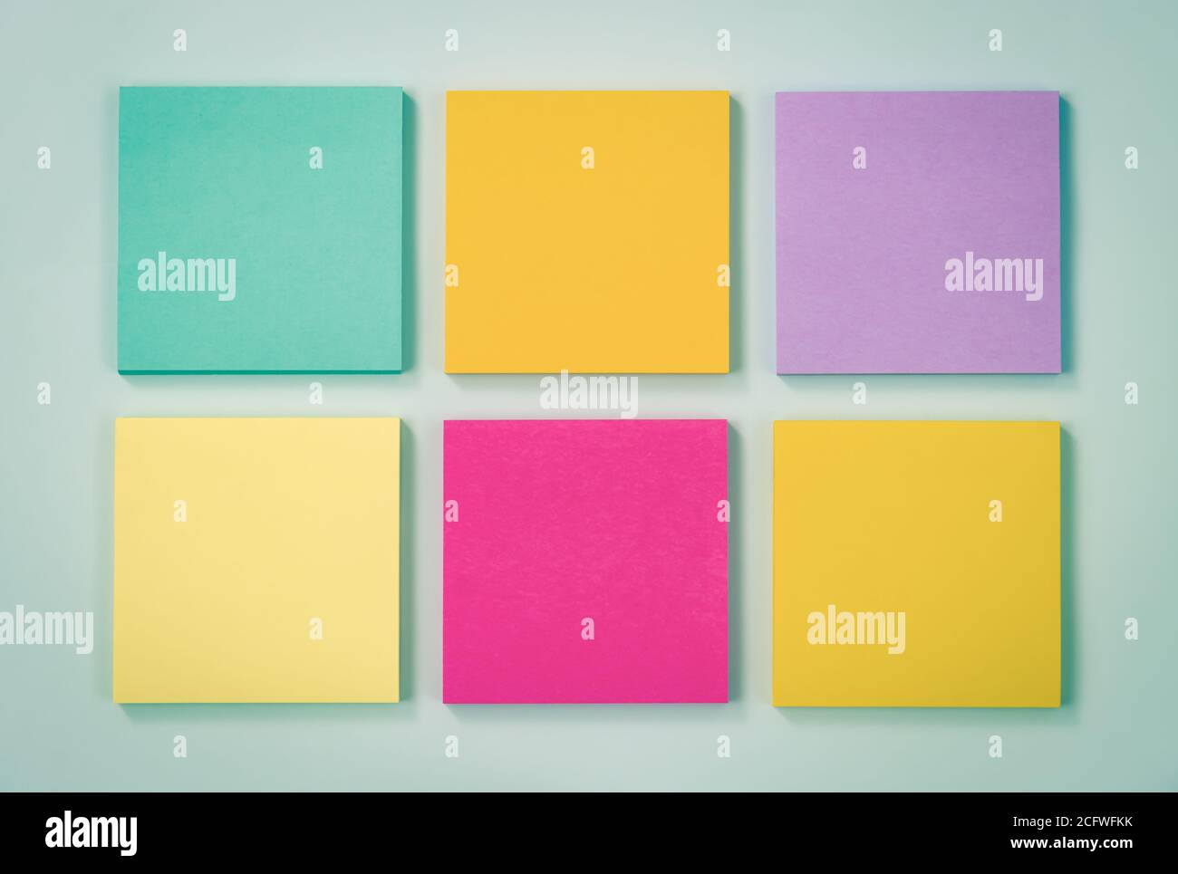 6 Farbe Haftnotiz oder Notizblock als Grün, Lila, Rosa, Gelb auf modernen sauberen kreativen Schreibtisch oder Bürotisch auf der Oberseite Ansicht. Bürobedarf auf Blau Stockfoto