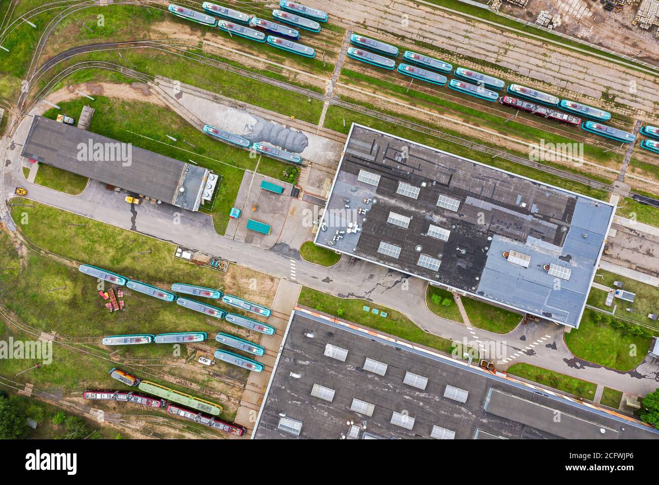 Straßenbahndepot in der Stadt. Straßenbahnen, Straßenbahnschienen und Industriegebäude. Luftaufnahme von oben von fliegender Drohne Stockfoto