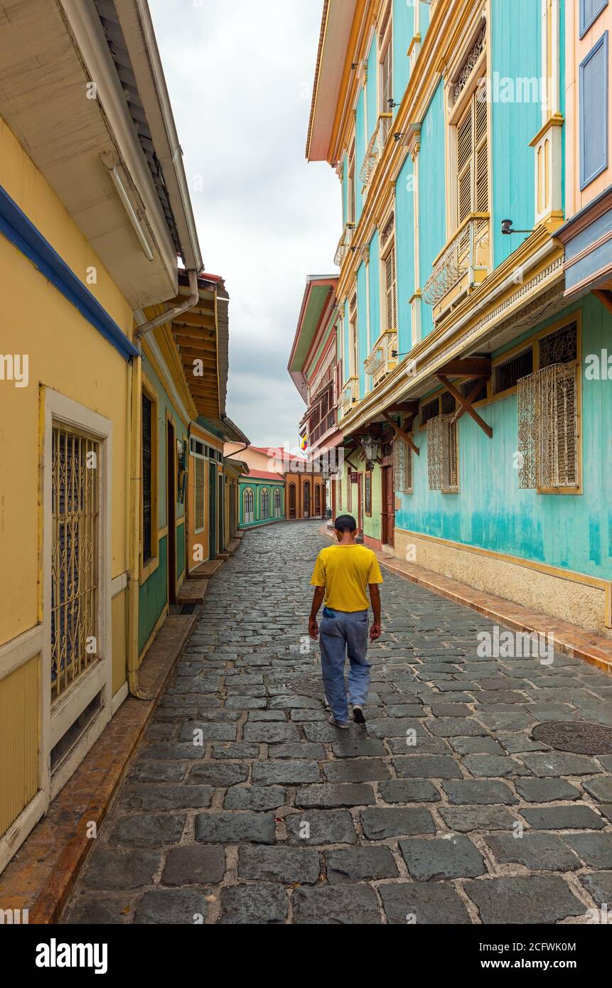 Ecuadorianischer Mann, der in einer farbenfrohen Straße im Kolonialstil spaziert, Guayaquil, Ecuador. Stockfoto