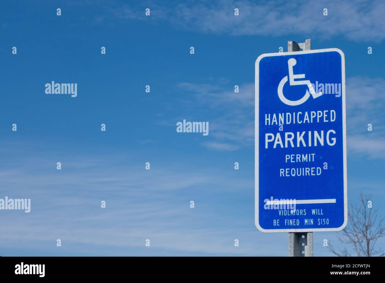 Blaues und weißes Schild auf einem Parkplatz mit der Aufschrift Nein Parkplatz nur für Symbol des behinderten Personals Symbol Grafik Stockfoto